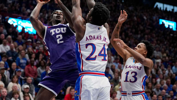 Jan 6, 2024; Lawrence, Kansas, USA; TCU Horned Frogs forward Emanuel Miller (2) shoots against Kansas Jayhawks forward K.J. Adams Jr. (24) and guard Elmarko Jackson (13) during the first half at Allen Fieldhouse. Mandatory Credit: Jay Biggerstaff-USA TODAY Sports